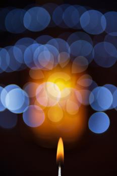 abstract christmas lights bokeh with candle flame 