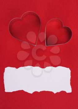 two metal hearts shaped over red background