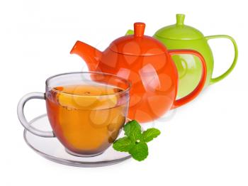 Glass cup of tea with mint leaves and two  teapots isolated on white background 