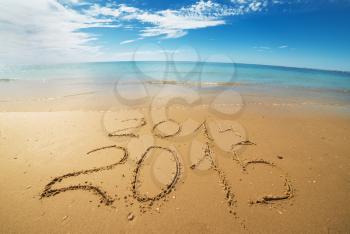 digits  2014 and 2015 on the seashore  sand - concept of new year and passing of time