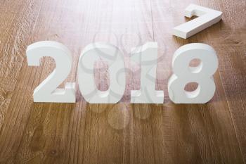 White digits 2018 and digit 7 on rustic  wooden background as concept of New Year and Christmas.

