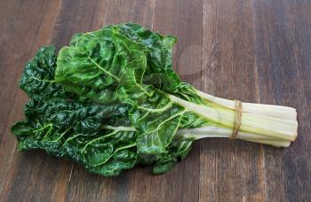 fresh green silverbeet leaves vegetable on  old wooden background