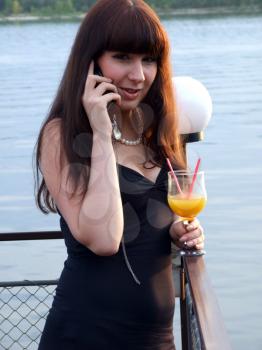 Royalty Free Photo of a Woman With a Drink Talking on a Cellphone