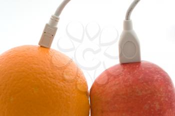 Royalty Free Photo of an Orange and Apple Connected to Cables
