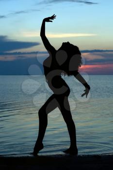 Royalty Free Photo of a Woman on the Beach at Sunset