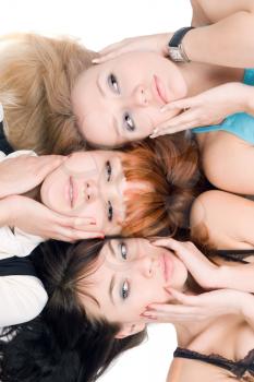 Royalty Free Photo of Three Women Lying With Their Hands at Their Faces