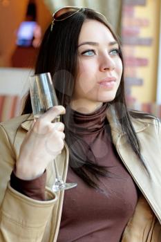 Portrait of pretty thoughtful lady holding a glass of champagne. Isolated on white