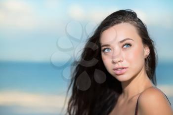 Portrait of thoughtful young brunette on the beach