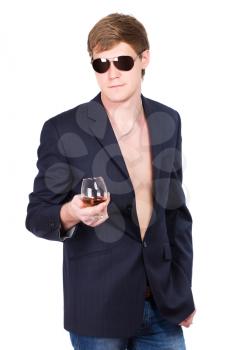 Young man in sunglasses and jacket posing with a glass of whiskey. Isolated
