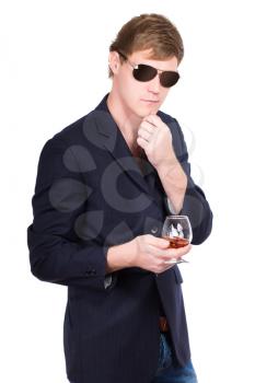 Man in sunglasses and jacket posing with a glass of whiskey. Isolated