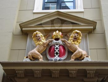 Amsterdam coat of arms on the facade of the city building. Netherlands