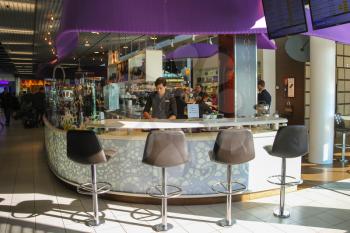 Amsterdam Schiphol, Netherlands - April 18, 2015: Bartenders serve customers in the cafe  at the airport Amsterdam Schiphol, Netherlands