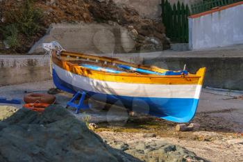 Tricolor boat on the beach of the Tyrrhenian Sea on Elba Island, Italy