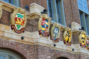 Old building with coat of arms on facade in the historic city center. Amsterdam, the Netherlands