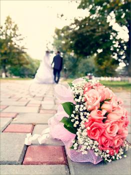 Royalty Free Photo of a Bridal Bouquet With the Couple in the Background