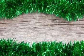 New year frame  with green garland on the wooden background