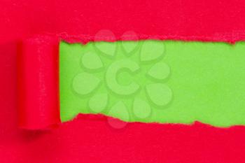Red paper torn to reveal green panel ideal for copy space