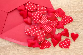 Envelope with red hearts on the wooden background
