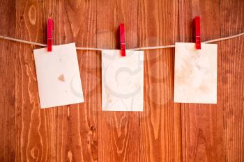 Photo  frames hanging on a rope over wooden background