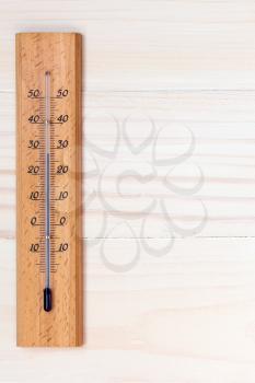 Thermometer on wooden background with copy-space for text