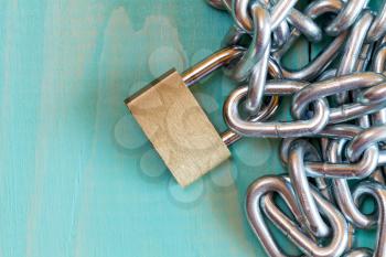 Chains and padlock on the blue wooden background