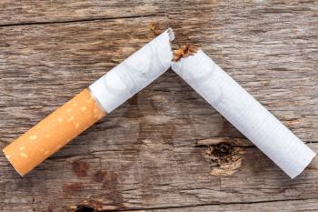 Close-up of broken cigarette on wooden background (Quit smoking today). 