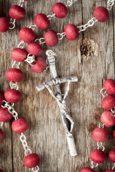 Catholic rosary on old wooden texture background