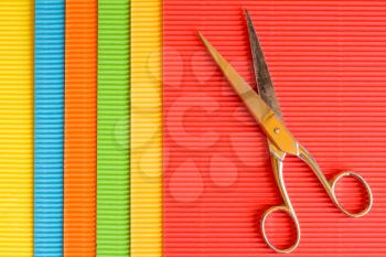Old scissors on colored corrugated paper background