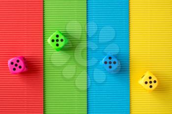 Four dices on colored corrugated paper background