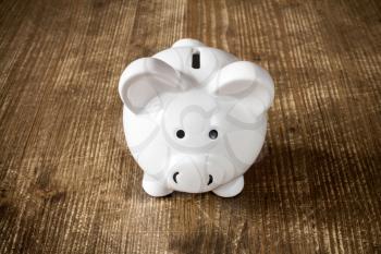 Piggy bank on the old wooden background, front view