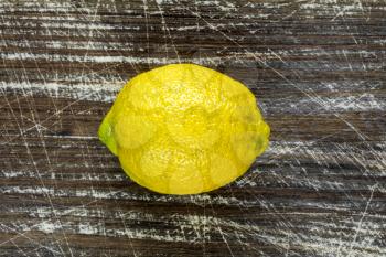 Fresh yellow lemon on the wooden background