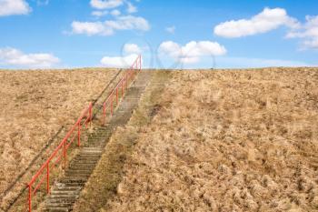 Concrete stairs up a grass hill, conceptual image