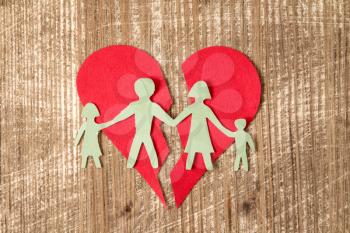 Paper family with broken heart on wooden table , divorce concept