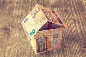 House made of Euro banknotes on a wooden background