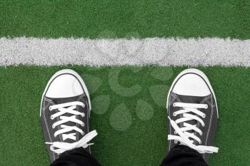 Top view of sneakers on the artificial grass with white line
