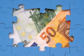 Euros hidden under puzzle, business concept of solution