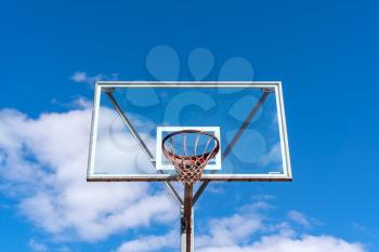 Basketball hoop against blue cloudy sky