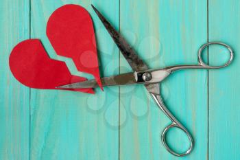 Paper red heart cuted by scissors. Divorce concept.