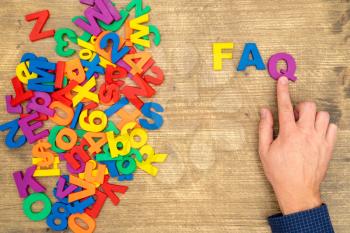  Hand arrange plastic letters as FAQ abbreviation ( frequently asked questions )