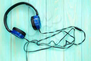 Wired stereo headphones  on blue wooden background 