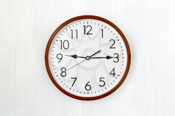 Simple round clock on a wooden background