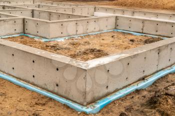 New housing construction site. New concrete house foundation with waterproofing.