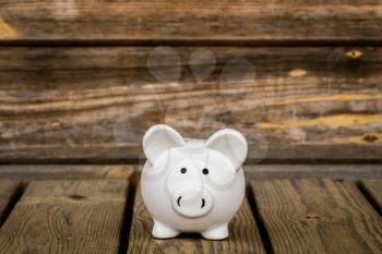Piggy bank on the wheatered wood background. Financial savings concept.