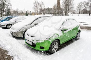 Parking lot with cars covered in fresh snow