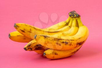 Bunch of overripe banana on pink background