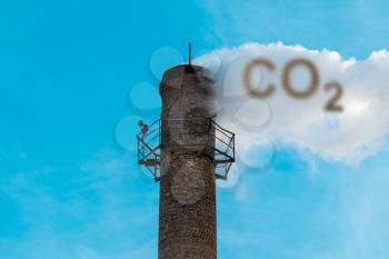 Smoke of chimney writing CO2 in the sky. Factory chimney and smoke polluting environment.