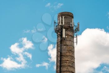 Old  brick chimney with mobile phone antennas. Lighting conductor on the top.