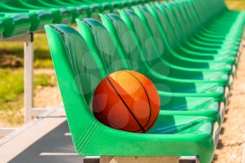 Line of stadium chairs with an orange basketball