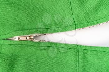 Unzipped zipper on a green sweater. Copy space. Close up.