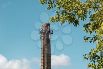 Factory chimney on a background of sky and trees